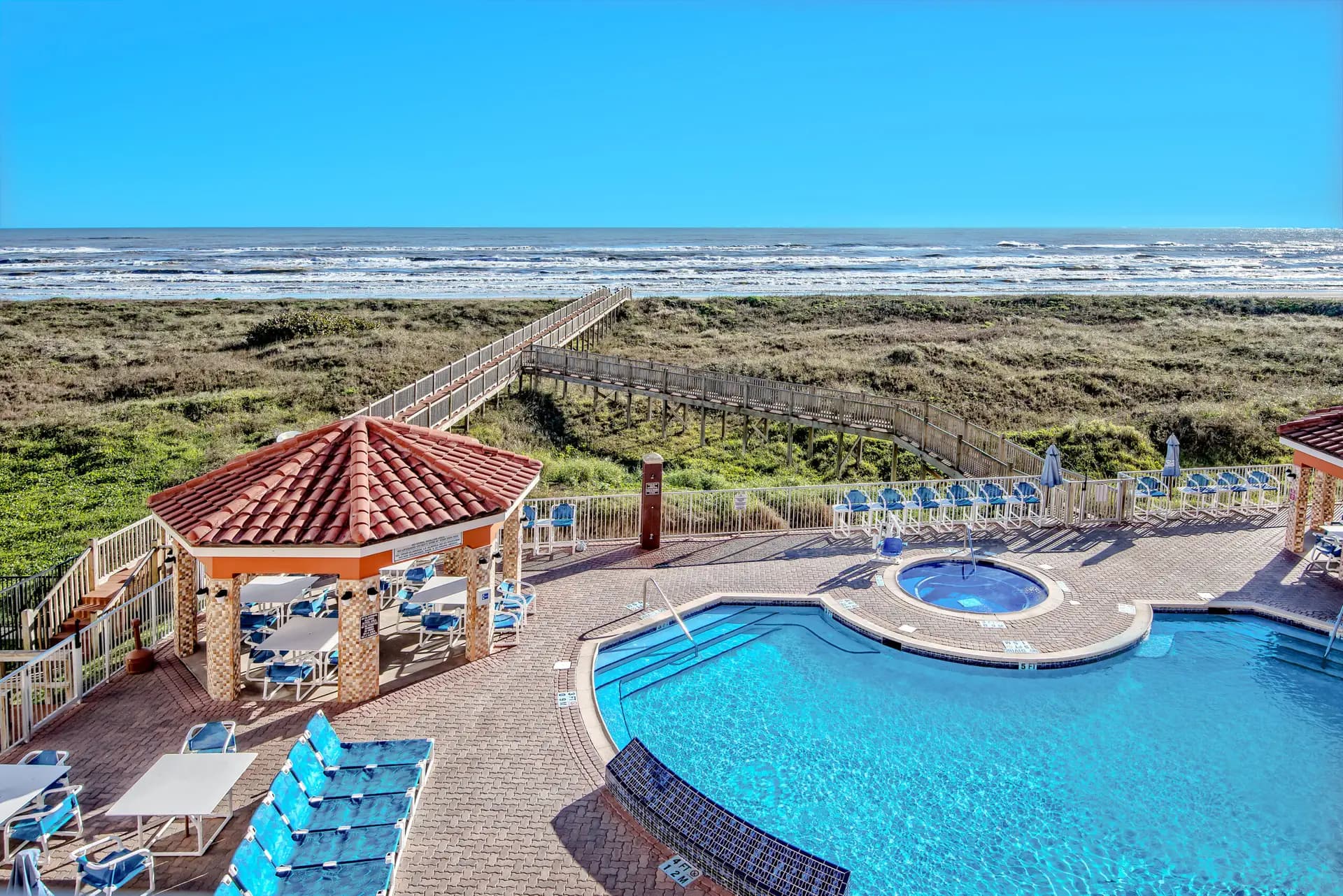 The pool deck, hot tub and gazebo, with the boardwalk to the beach